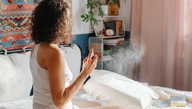 Woman Spraying On Pillow